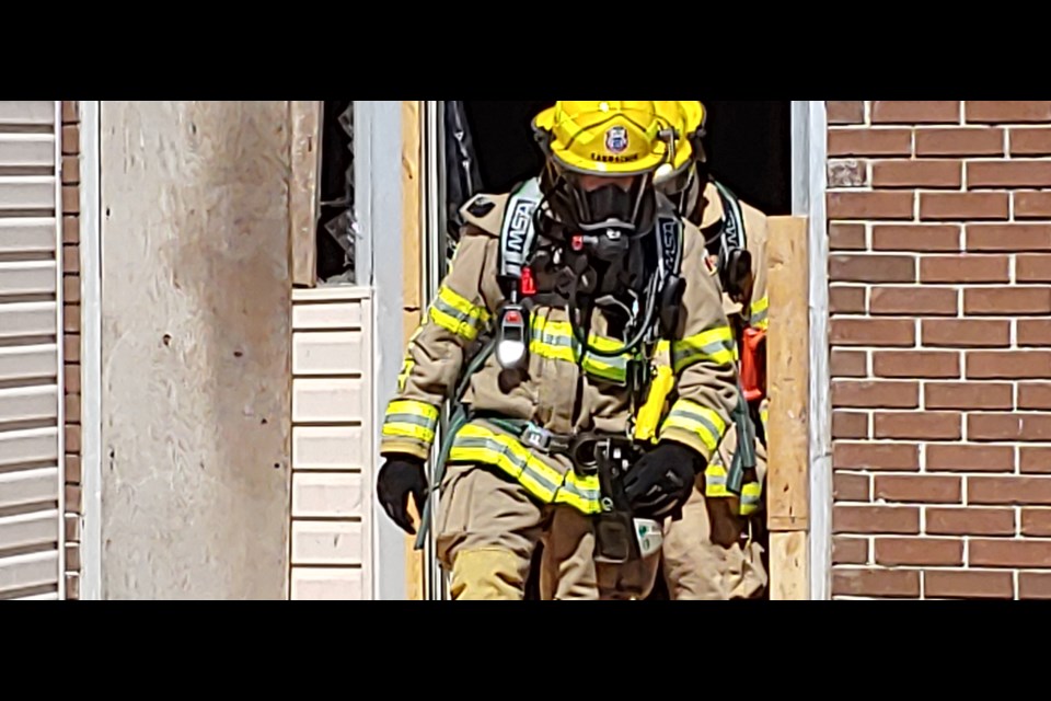 NBFES firefighters exit the former Sands Motel while responding to a small structure fire, Friday. Photo by Stu Campaigne.