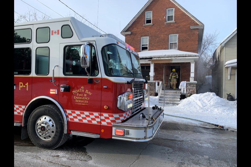 Firefighters cleaning up outside this home on McIntyre Street East Saturday morning.  Photo by Chris Dawson/BayToday. 