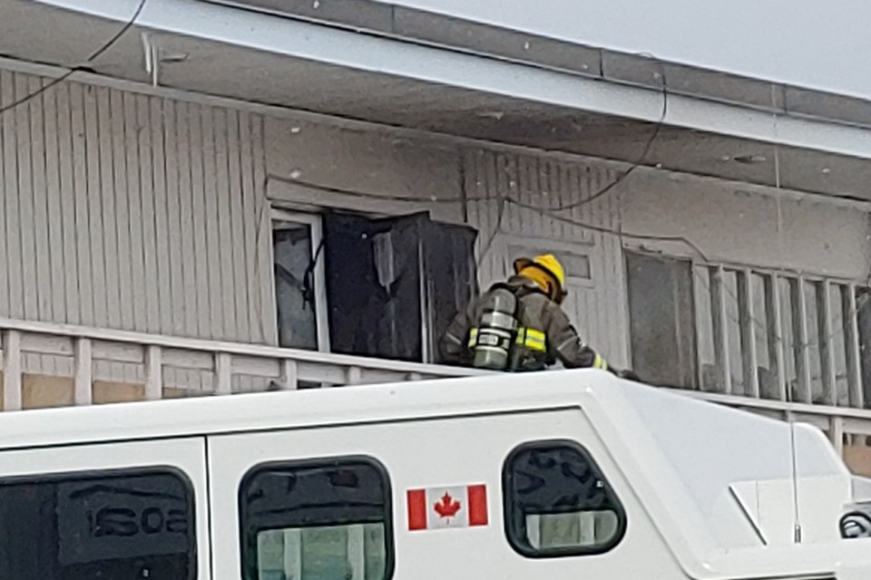 A firefighter exits the heavily damaged unit where the fire originated.