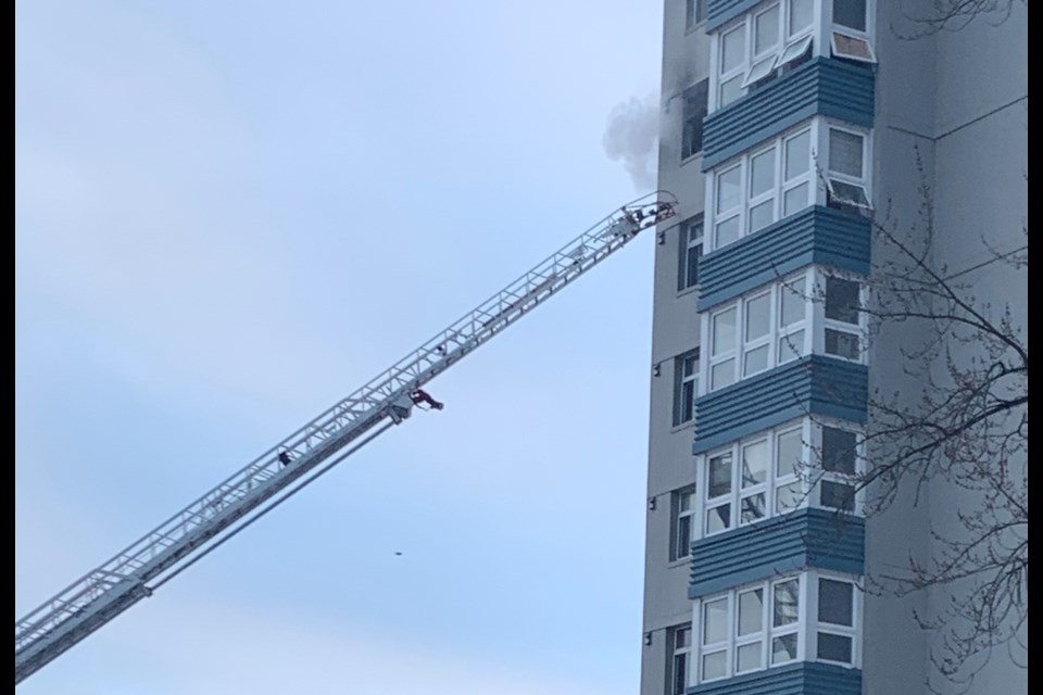 Smoke can be seen coming from this eighth-story window.