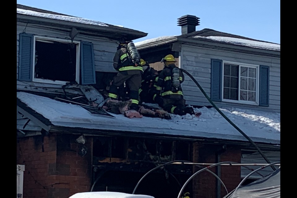 Fire crews go through a window to put out hot spots.  Photo by Chris Dawson/BayToday. 