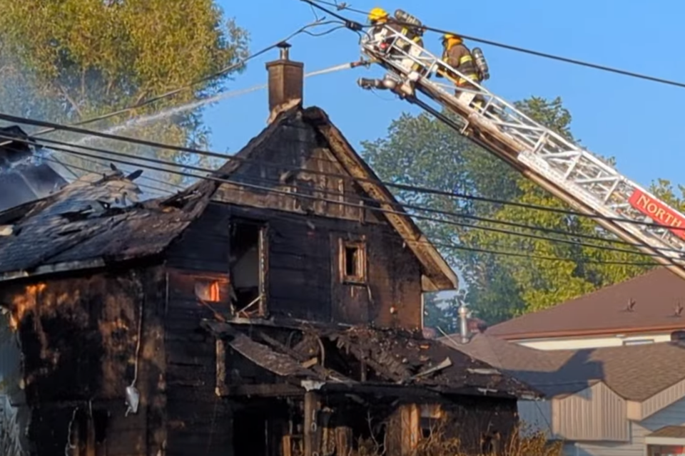 North Bay Fire and Emergency Services crews battle the heat and a fully-involved fire at 1070 Main St W on Monday.