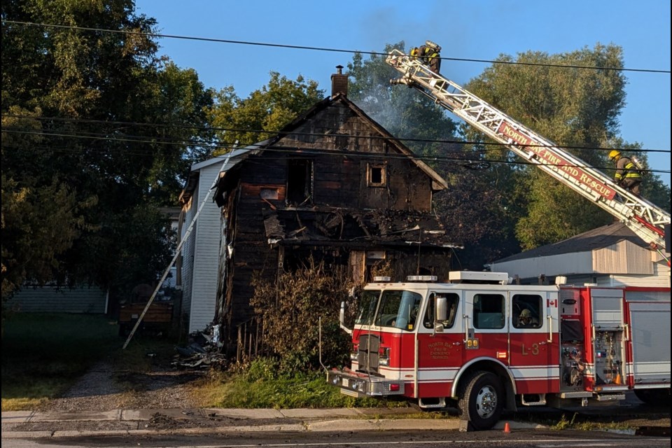 North Bay Fire and Emergency Services crews battle the heat and a fully-involved fire at 1070 Main St W on Monday.