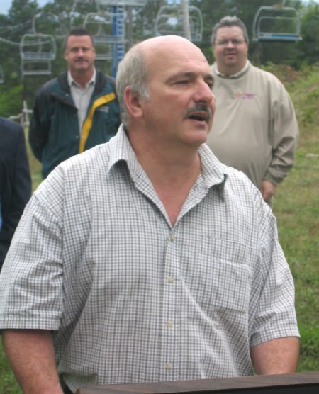 Tim Robb, one of the members of the Save Our Ski Hill Committee, talks about his reasons for wanting to save the hill.  Cogeco North Bay News programing director Brian Winkworth (L) and Rogers Radio general manager Peter McKeown watch in the background. Photo by Phil Novak.