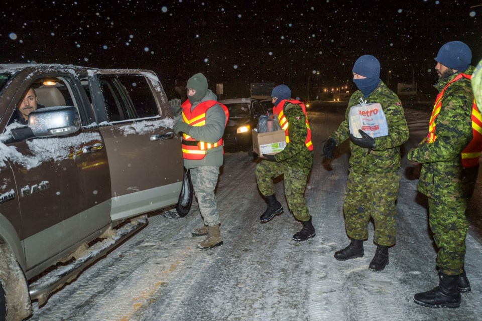 Personnel and civilians heading to Canadian Forces Base North Bay donate money and non-perishable food in support of the Food Bank. Photo: Master Corporal Alana Morin, 22 Wing Imagery Section, North Bay.