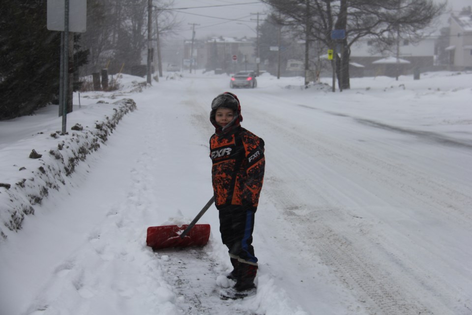 USED20180124 4 Gavin Paytt, aged 9, does his civic duty by clearing off the sidewalk during a snowstorm. Photo by Brenda Turl for BayToday.