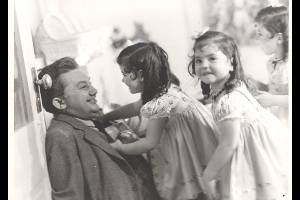 The man in the photos is actor Jean Hersholt. These photographs are special because they show the girls being more natural than the ones published.