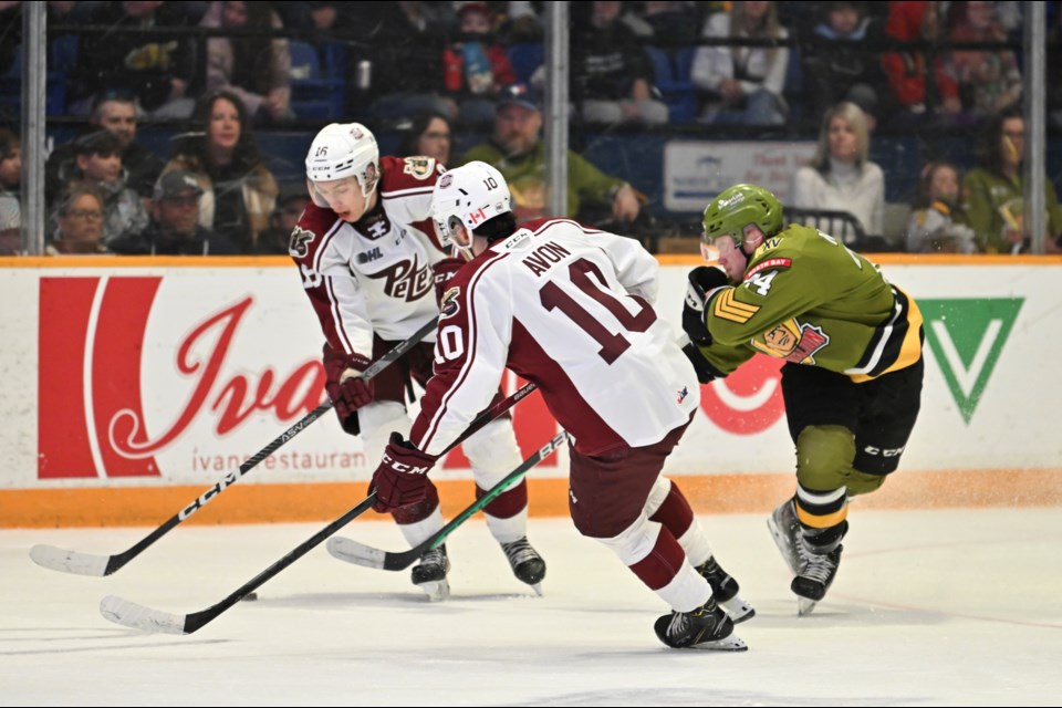 J.R. Avon and Owen Beck try to get the puck away from Ty Nelson. Photo by Tom Martineau/BayToday. 