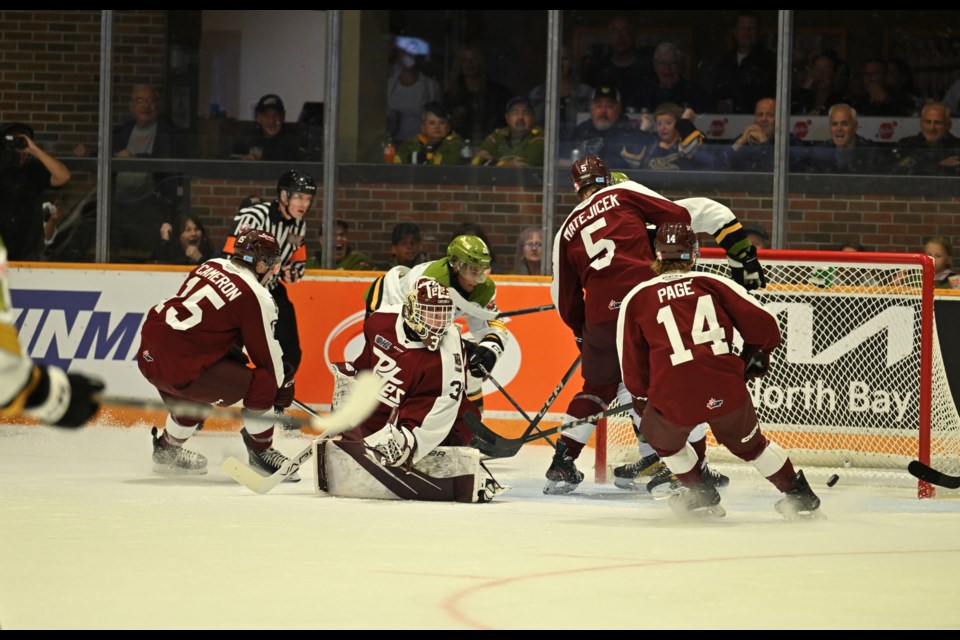 Natan Teshome watches the puck slip by Petes netminder Zach Bowen. 