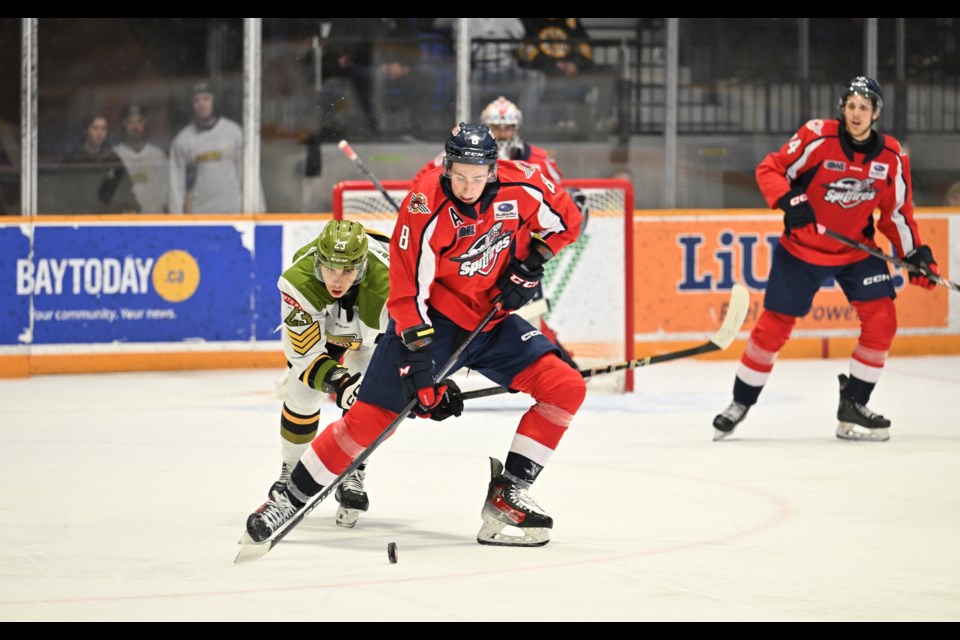 Spits AJ Spellacy with the puck and former Battalion defender Tnias Mathurin in the background. 