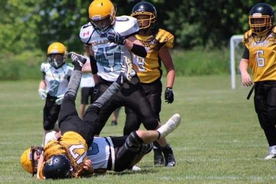 Porter Hermann-McKay sacks the TNT Express quarterback with Gage Campaigne (47) also in pursuit in Bulldogs U14 action in Beeton.