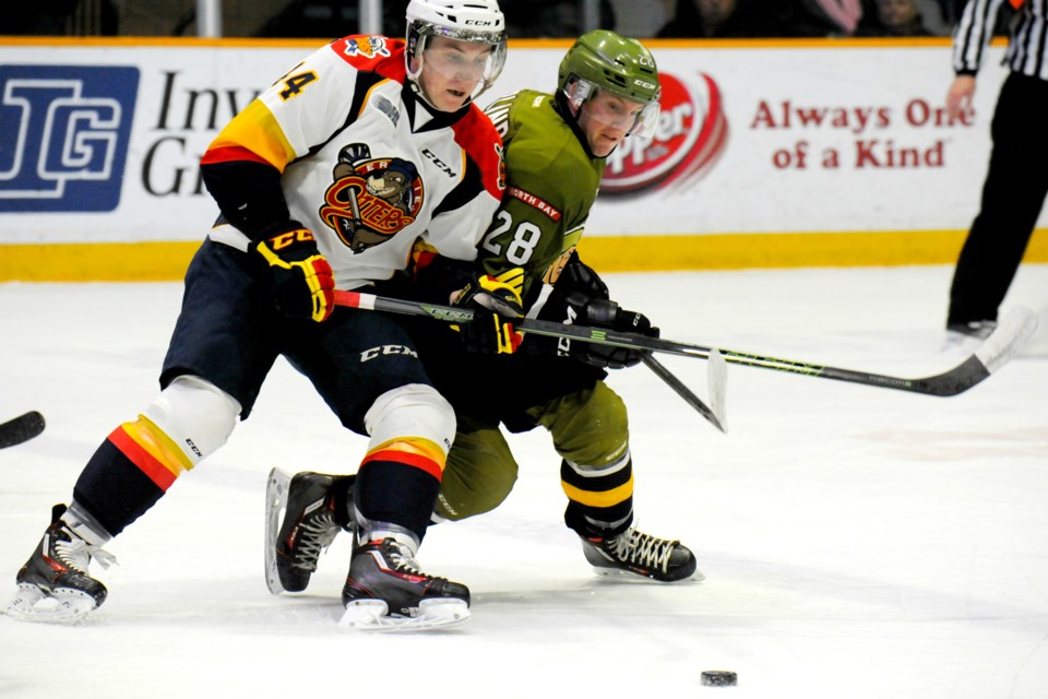 North Bay Battalion forward Steve Harland fights off Erie Otters' forward Travis Dermott in the Troops' 3-2 win on Thursday night. PHOTOS BY TOM MARTINEAU