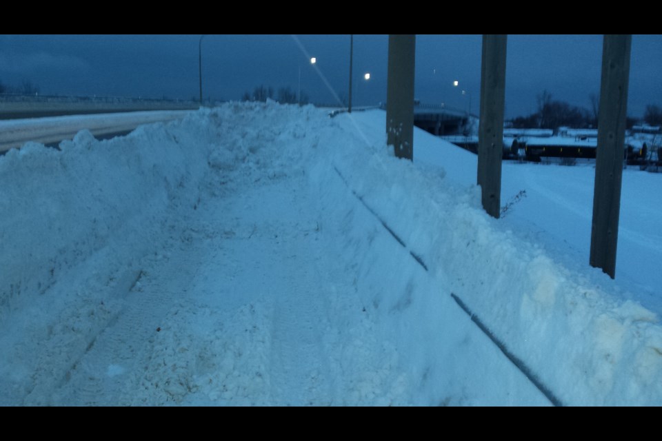 Snow piles on the sidewalk overpass around 7:30 this morning. CIty officials say the piles were cleared away around 8 a.m. today.  Photo submitted. 