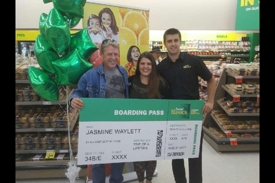 Jasime Waylett receives a cheque from North Bay Food Basics  store manager Jesse Grimes, with dad Dan by her side, after winning a store contest 
photo courtesy Jesse Grimes