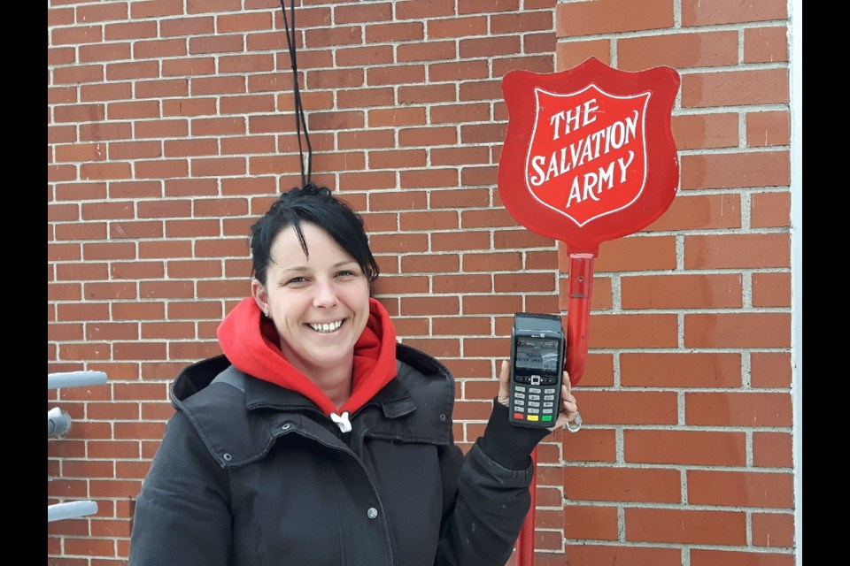 Emmi Lunel holds up one of the debit machines used by the Salvation Army as part of a pilot project for its Kettle campaign.