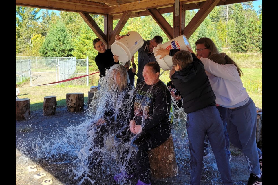 Principal Micheline Lamarche and vice-principal Rhonda Lindeman live up to their end of the deal and let the students (and parents of the students, those buckets are heavy) pour water over them / Photo David Briggs