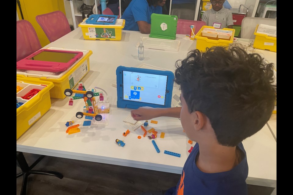 A student demonstrates a ferris wheel operated through a computer.