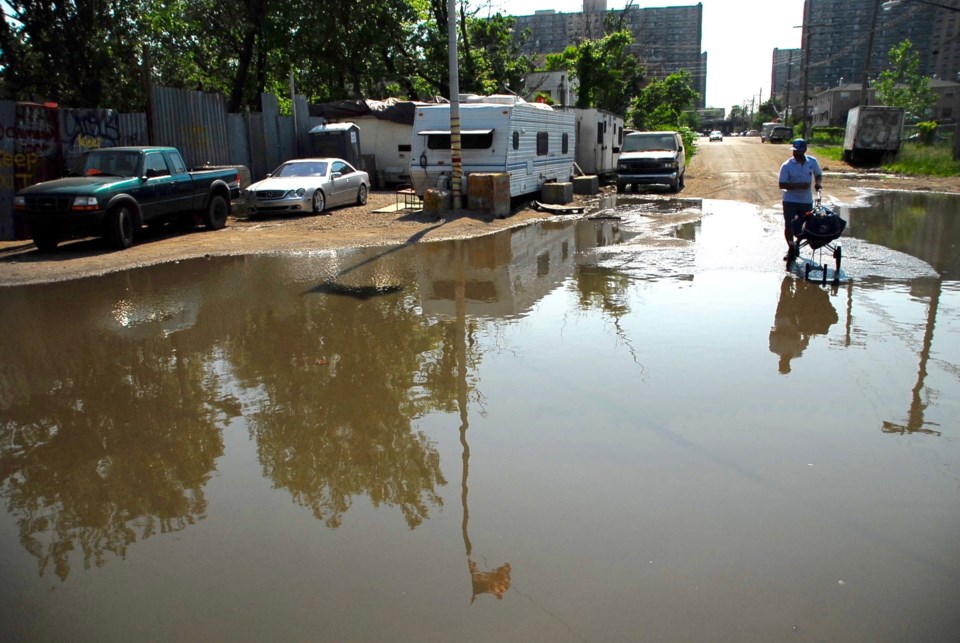 A mailman navigates the flooded Jewel Streets area, aka "The Hole".