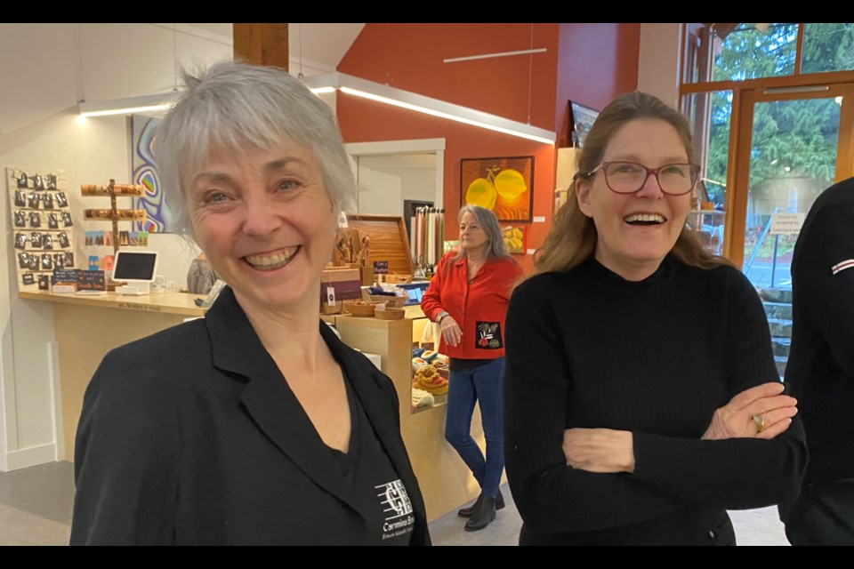 Gillian ‘Gill’ Haley and friend Gail Percy arrive at the ‘Paintings
& Piano’ exhibition on opening night at the Hearth Gallery in Snug Cove. The two later sang in a performance of a 16th century song with Carmina Bowena, an island a-cappella choir that highlights the music of the Renaissance.