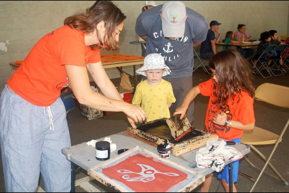 Making a silk screen hummingbird flag during Canada Day Reimagined in 2022. 