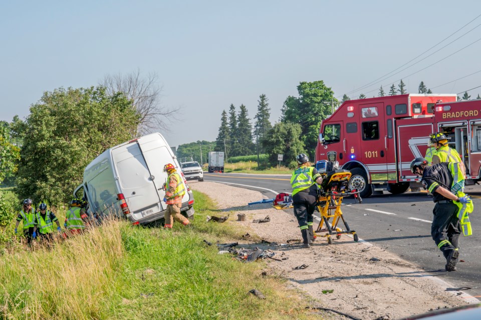 Fire crews and paramedics rush to extricate a driver from the van.