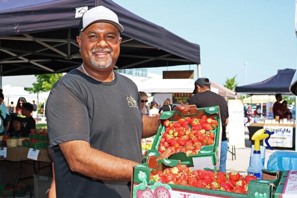 Shane Singh owner of Springh Farms shows some of their strawberries available at the Bradford Farmers’ Market at the Bradford West Gwillimbury Public Library during the strawberry festival on Saturday, July 13.