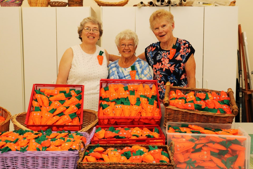 From left: Jan Evans, first vice-president; Olga Bishop long-time member; and Elke Pitkin, president; show the many Gwilly pins made by the Bradford Seniors Association at the Danube Seniors Leisure Centre on Tuesday, July 23.