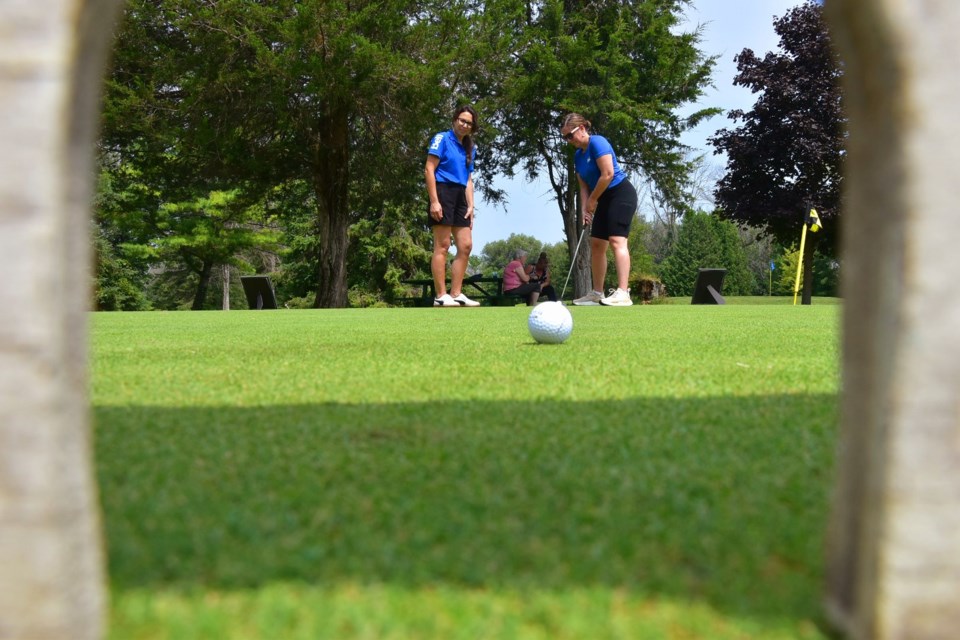 Totally One Communications representatives Lori Harvey, right, and Teresa Fedrigoni gave a putting challenge a try during the Bradford Board of Trade’s Open for Business golf tournament.