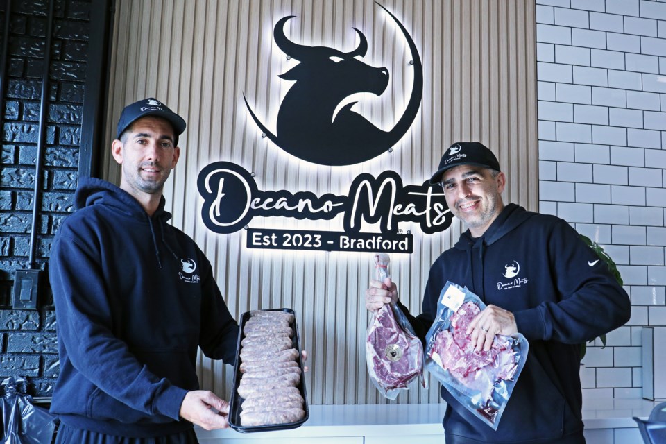 From left: Owners Nicolas Aguirre Acosta and Martin Cotarelo hold up some of the cuts on offer at Decano Meats, 95 Holland St. W., Unit 6, in Bradford, on Sept. 3.