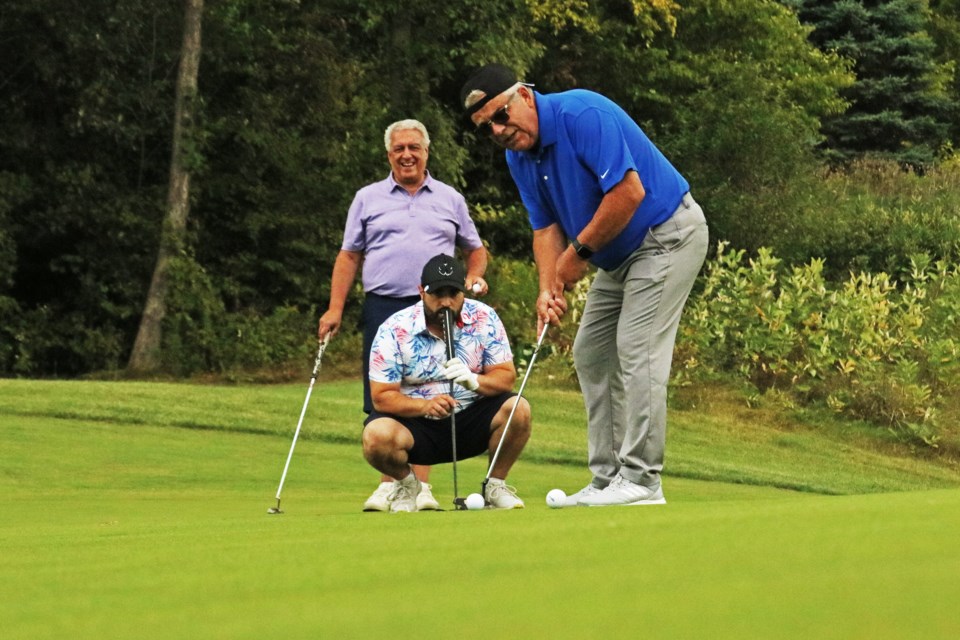 From left: Angelo Bitondo and Anthony Tiberini watch as Bradford Mayor James Leduc tries for a tricky putt on hole nine during the annual Mayor and Council Golf Classic at The Club at Bond Head on Sept. 6, 2024.