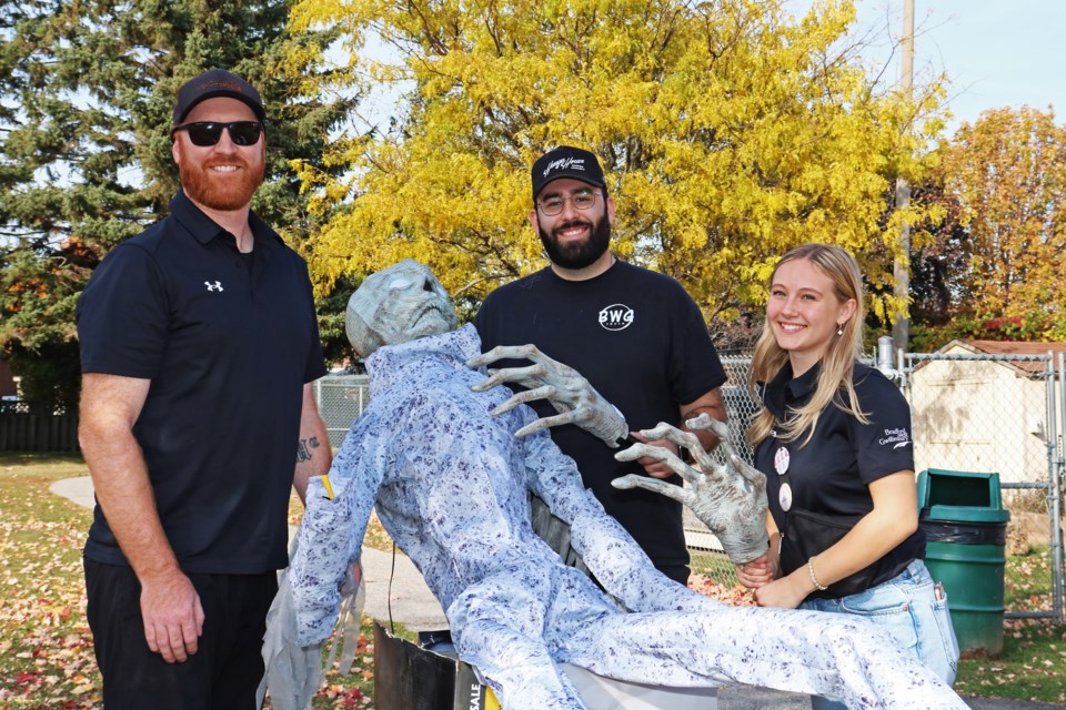 From left: The ‘Boo Crew’ Jeremy McNaught, recreation programmer, Nick Ferrara, youth programmer, and Cassidy Bone, recreation programmer, work to setup a giant skeleton to welcome guests to the haunted house at the BWG Youth Recreation Centre on Oct. 22.