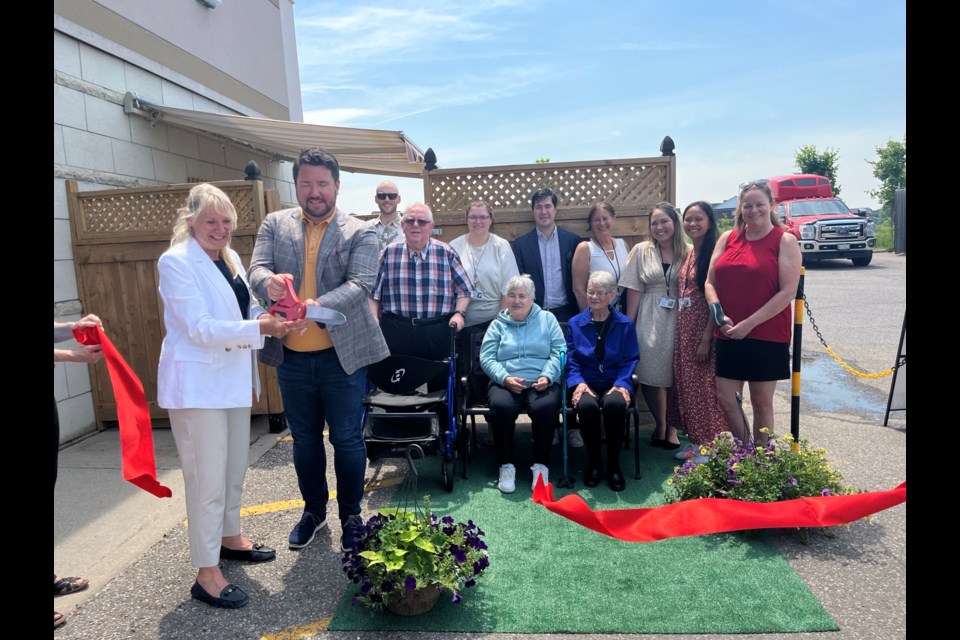 Christina Bisanz and Jonathan Scott but the ribbon to mark the opening of the garden at the CHATS senior day program in Bradford.