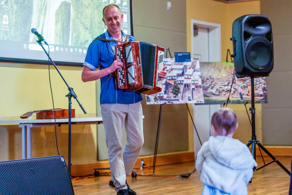 Andrey Melnyk is all smiles as he plays his accordion for Mila his granddaughter. 