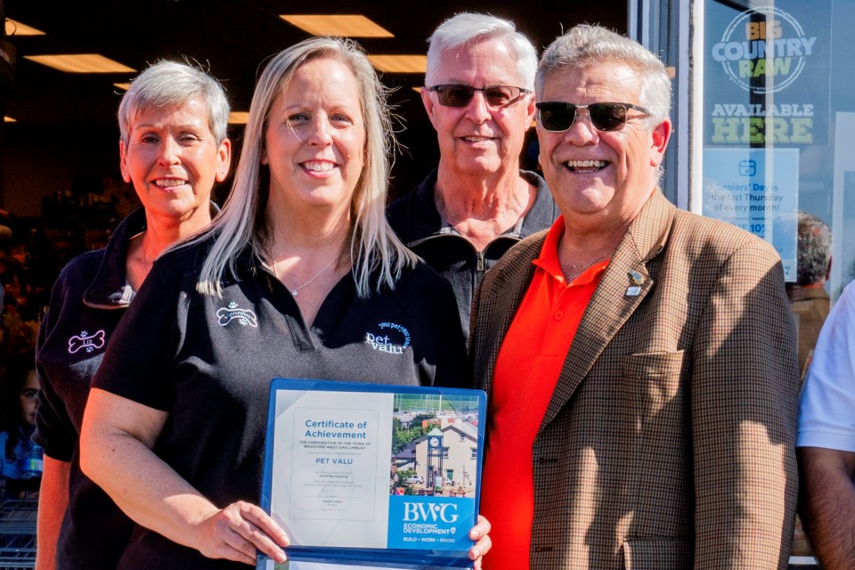 Bradford Mayor James Leduc presented Jennifer Pegg with a Certificate of Achievement at the re-opening of Pet Valu Bradford Saturday. She bought the store from her retiring parents, Liz and Bob Pegg, also pictured.