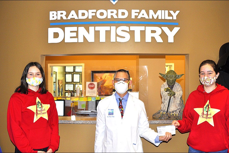 Dr. Jesse Chai, owner of Bradford Dentistry, donated a cheque for $1000 to A Bradford Christmas organizers Emily (left) and Sarah (right) Dahlgren who have currenrly raised over $31K for the Helping Hand Food Bank's Holiday Hamper program.    JackieKozak/BradfordToday