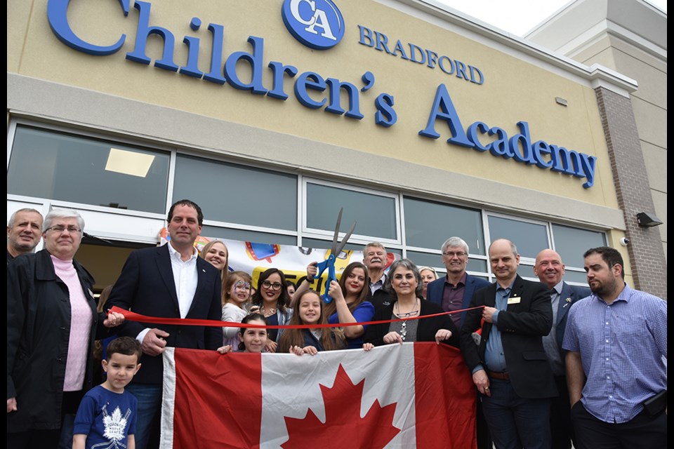 Owners, staff and special guests get ready to cut the red ribbon and open the Bradford Children's Academy. Miriam King/Bradford Today