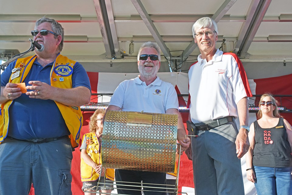 From left, Lion Jim Slykhuis announces the Early Bird winner as Lion Dietmar Jeske and Mayor Rob Keffer look on, at Canada Day celebrations in Bradford. Miriam King/Bradford Today