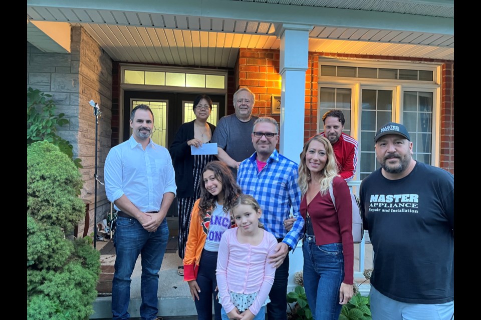 Joe Giordano and family, Nickolas Harper, Flavio DiGiovanni, and Jerry Ledo meet with the MasIsaacs Thursday at their home in Summerlyn Village to drop off the donation 