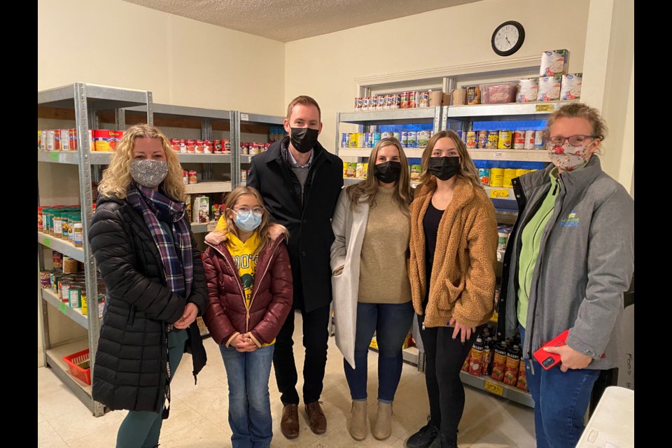 The Mullins family, Jason, Kristine, Brianna and Brooklyn, get a tour of the Helping Hand Food Bank after donating $25,000 to them in the Promise Church fundraising campaign, pictured here with food bank president Carolyn Khan and Promise Church member Cori Dean