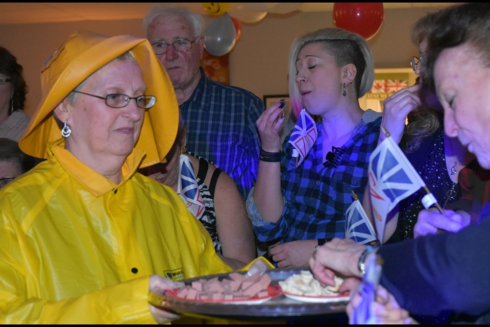 Alice Organ hands round a plate of bologna and hardtack, as part of the screeching in ceremony. Miriam King/Bradford Today