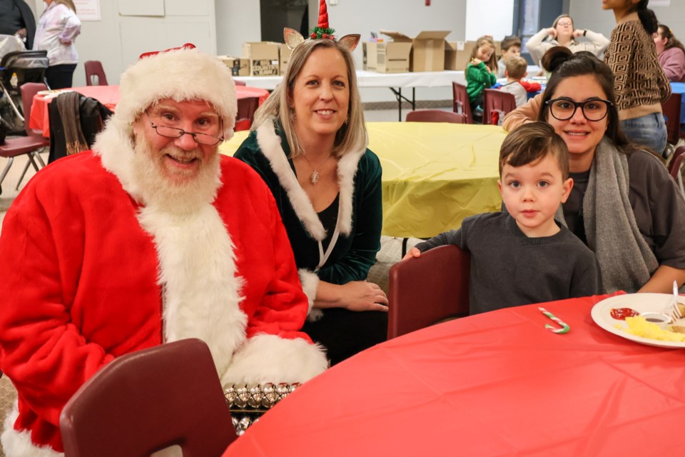 Santa and his Elf talking with guests.