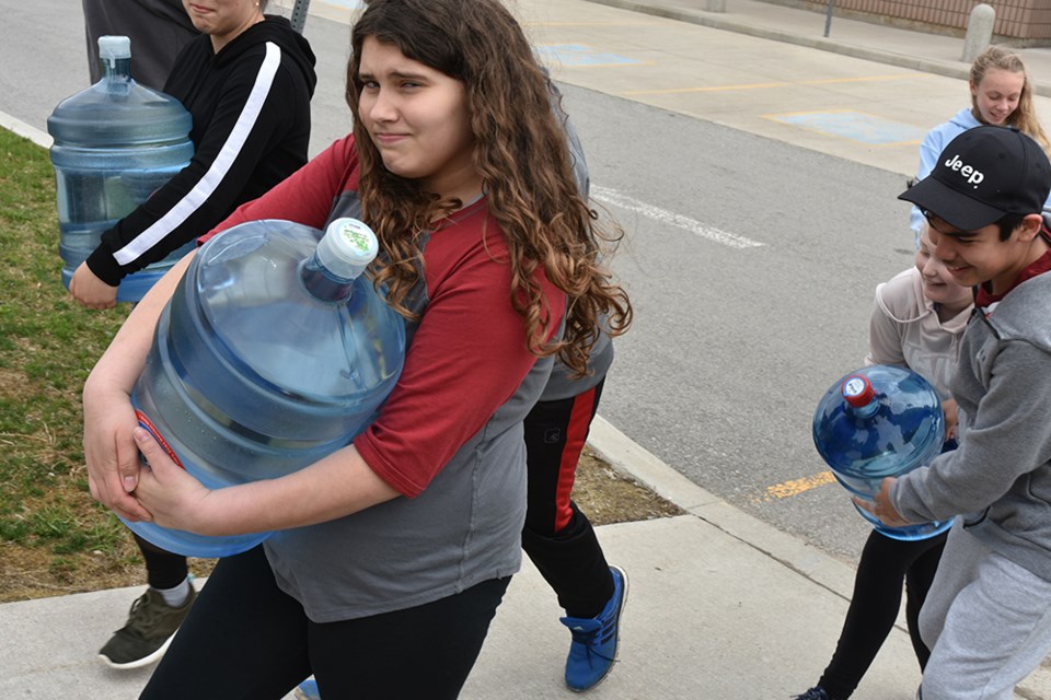 Student struggles with heavy bottle of water, bringing attention to the daily struggle of millions. Miriam King/Bradford Today