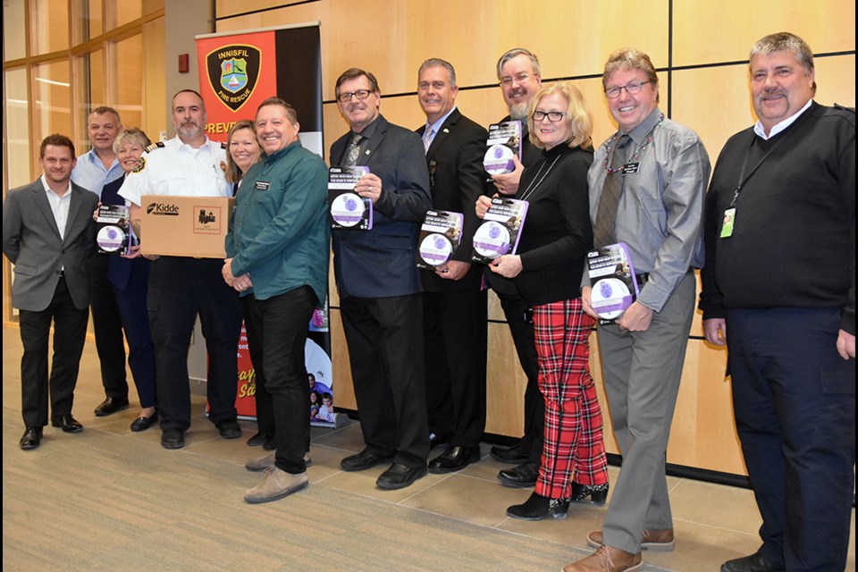 From left, Enbridge Gas representatives Mark Wilson and Grant Kilpatrick, Coun. Carolyn Payne, Deputy Fire Chief Tim McCallum, Mayor Lynn Dollin, Deputy Mayor Dan Davidson, councillors, and Fire Prevention Officer Mike Symes with CO alarms. Miriam King/Bradford Today