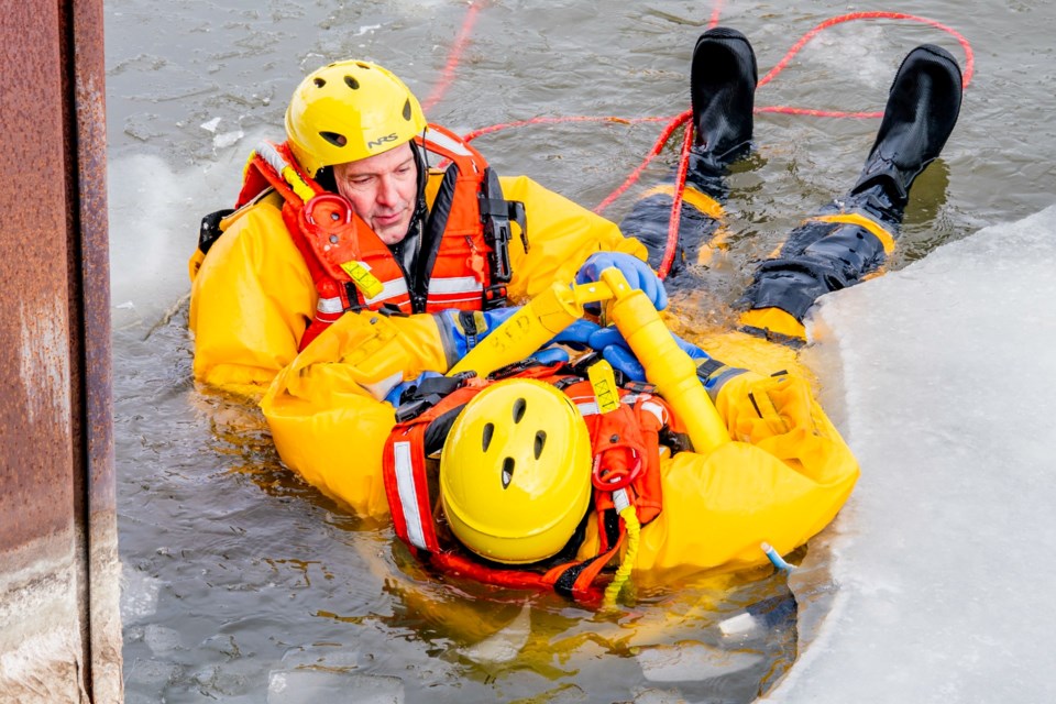 Bradford Fire volunteer firefighter Craig McLaughlin attaches a rescue sling to the patient in the freezing water.