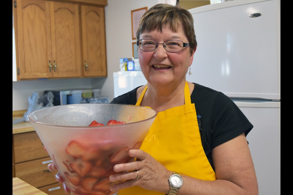 Cheryll Strong prepares a bowl of strawberries, for Bradford United Church's Strawberry Supper. Miriam King/Bradford Today