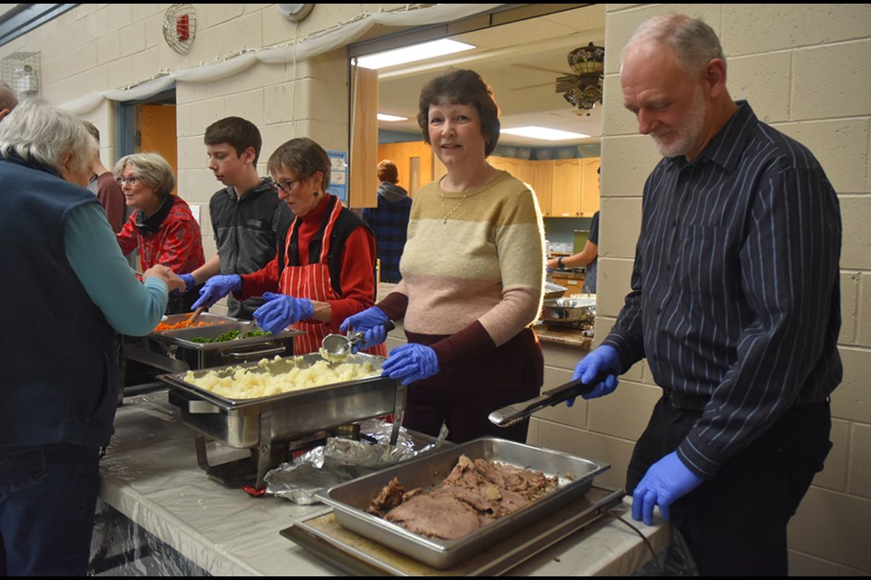 Assembly line of volunteers serving up Roast Beef and all the fixings, at Bond Head United Church's Roast Beef Dinner. Miriam King/Bradford Today