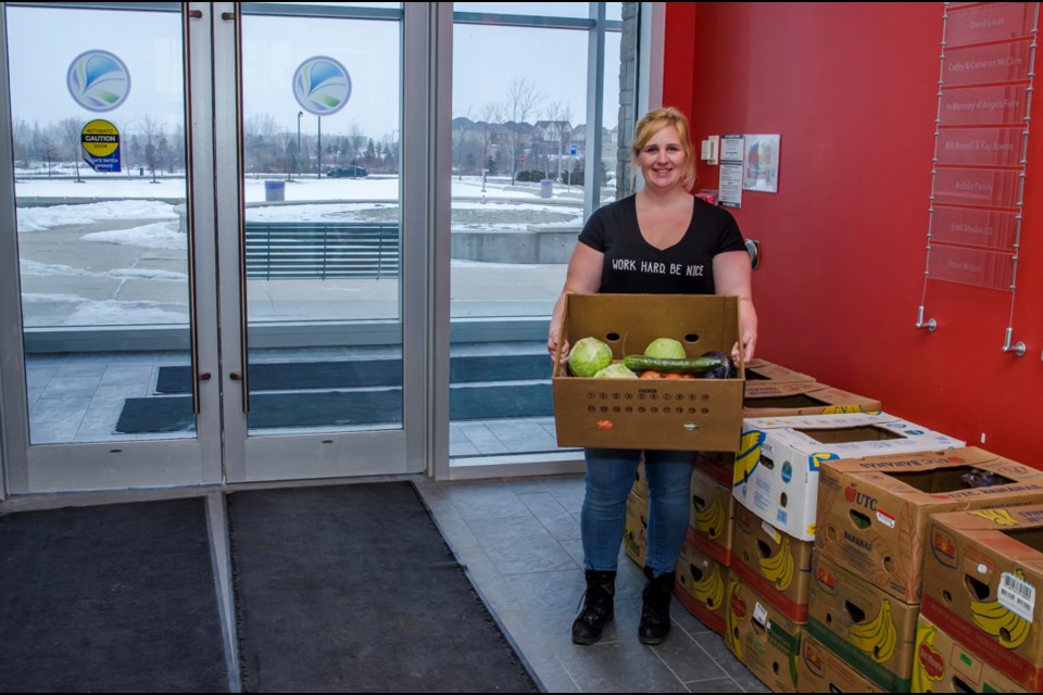 Amanda Moffatt, a volunteer with the Good Food Box Program hands out boxes of fresh fruits and vegetables to everyone who participatied in the first Good Food Box Delivery in Bradford. Dave Kramer for BradfordToday.