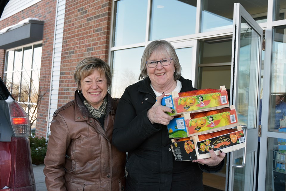 PACE Credit Union Alcona Branch manager Barb Trennum, left, and supervisor Laureen Payne deliver oranges to Innisfil Community Church. Miriam King/Bradford Today