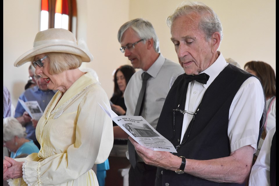 Ann Campbell, from left, Mayor Rob Keffer (in background) and David Chambers sing hymns inside the Auld Kirk. Miriam King/Bradford Today