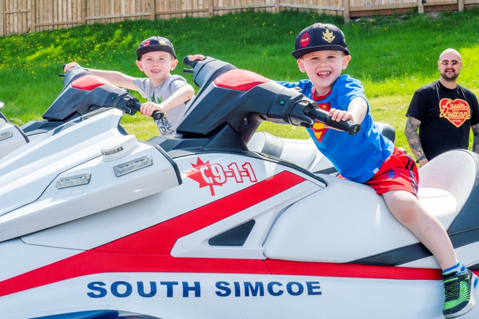 Lucas and Cooper hop on the South Simcoe Police patrol watercraft at Saturday's Open House in Bradford.